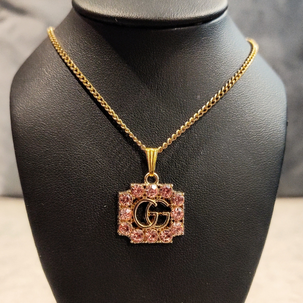GUCCI GG GOLD TONE PENDANT WITH PINK RHINESTONE ACCENTS ON GOLD PLATED NECKLACE